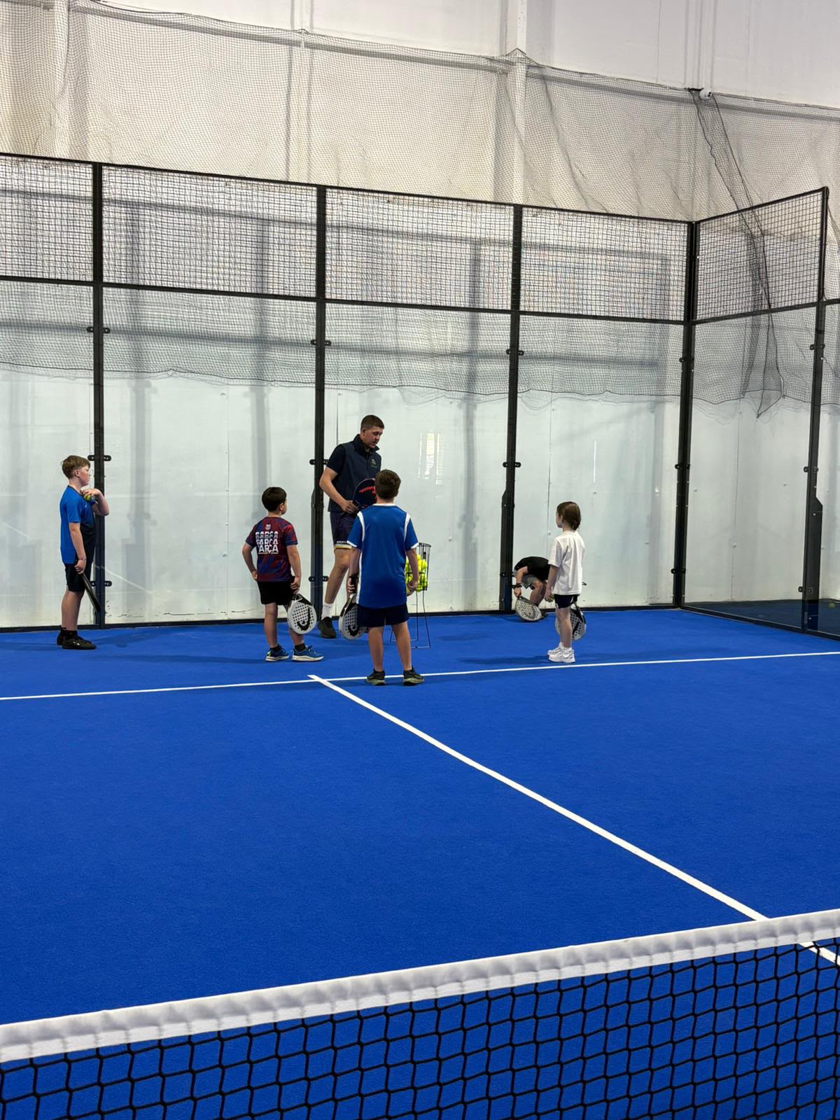 Coach Henry running a junior padel drill on the indoor courts at Poplars Padel, East Cowick